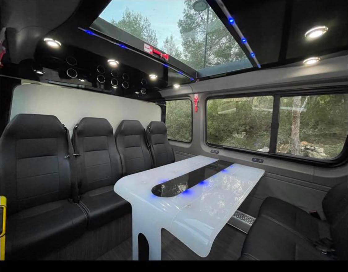 Lounge seating, table and lighting inside the party bus